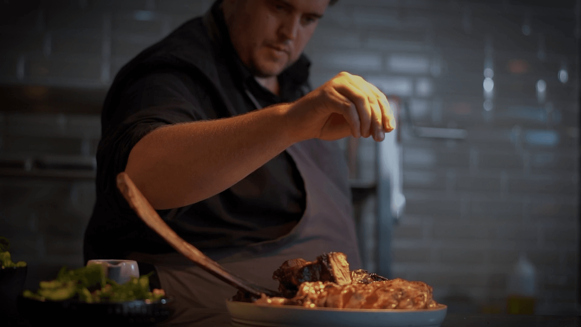 A private chef Bali service, sprinking the finishing touches to a meal